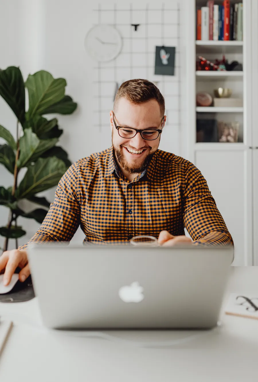 A smiling man on a video call at his laptop